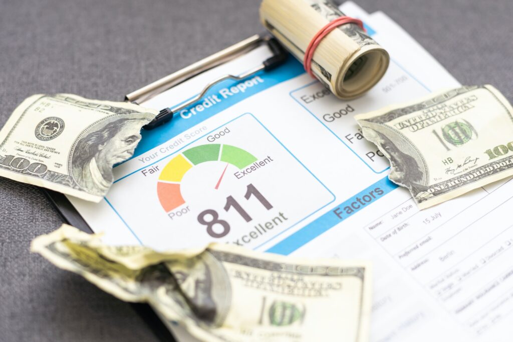 Magnifying glass on colourful pie chart with Credit report text on paper, dice, spectacles, pen