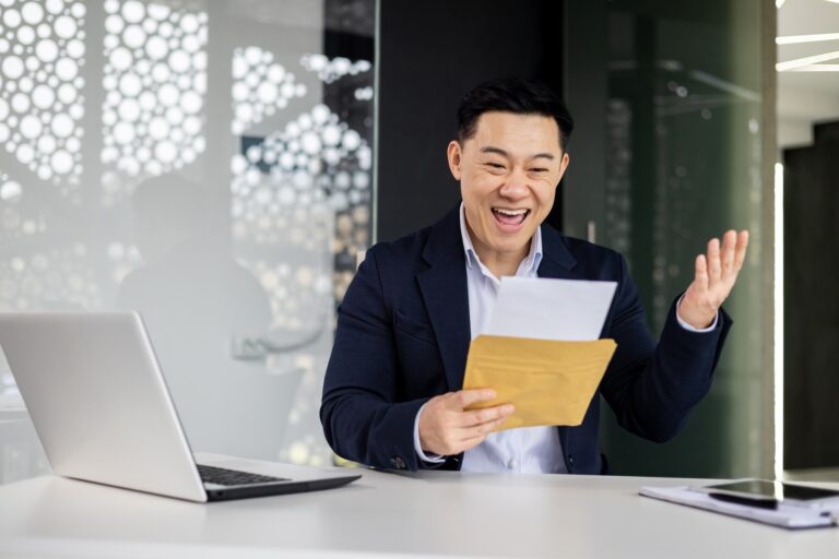 Businessman at work, Asian man reading a good letter from the bank about opening a credit line, the