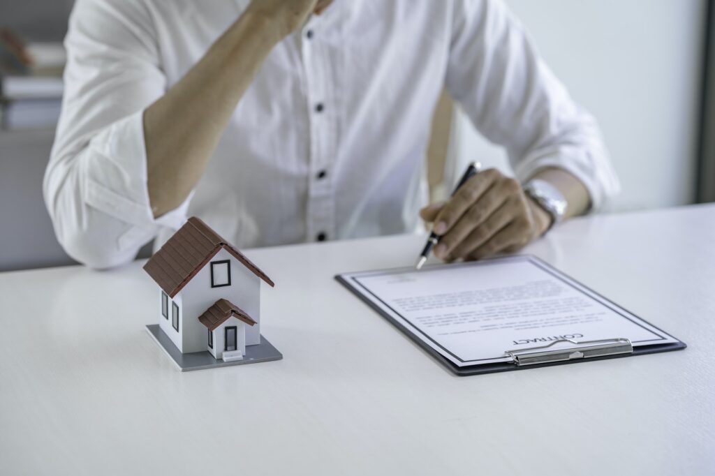 Businessman is thinking of signing a house and apartment rental contract in documents. Purchase agre