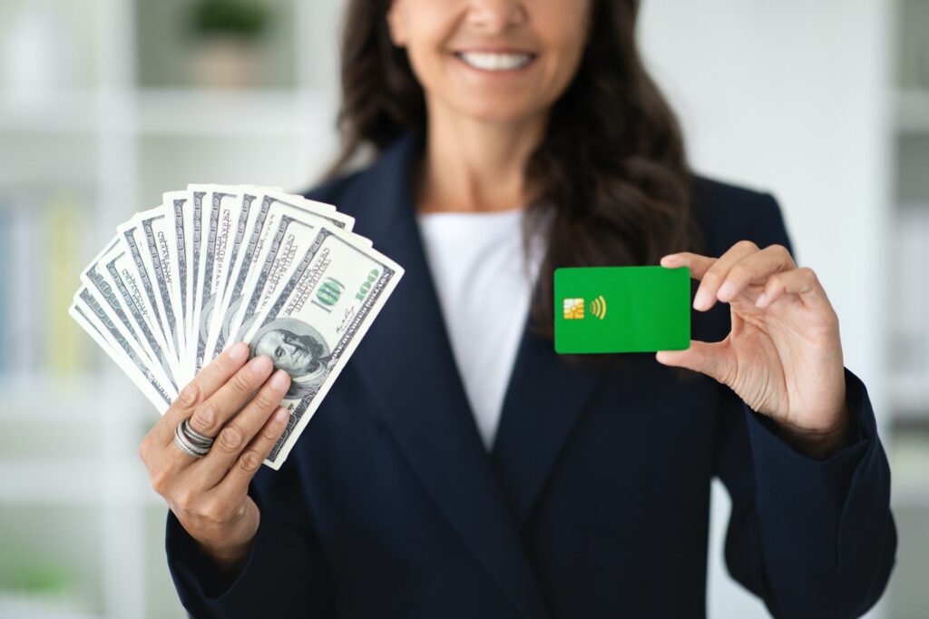 Cropped of businesswoman holding bank credit card and money cash