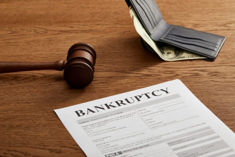 bankruptcy form with wooden gavel, dollar banknote and wallet on brown wooden table