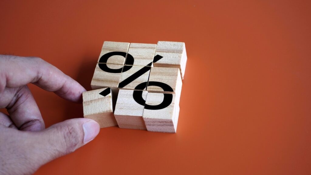 Hand arrange wooden cubes with percentage sign.